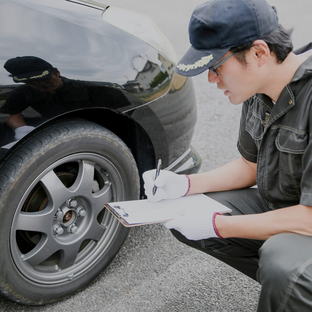 車の塗装の確認をするスタッフ